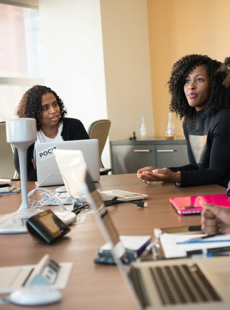 Diverse team of professionals engaging in a collaborative office meeting around a desk.